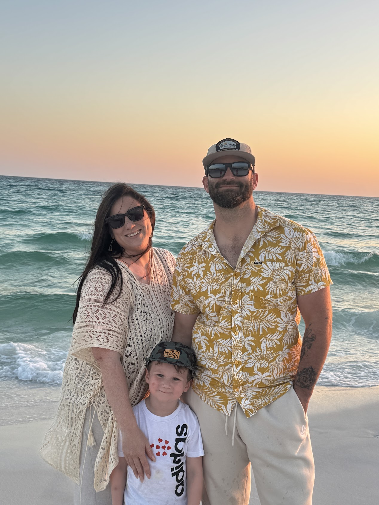 Jordan with his wife and son on the beach at sunset