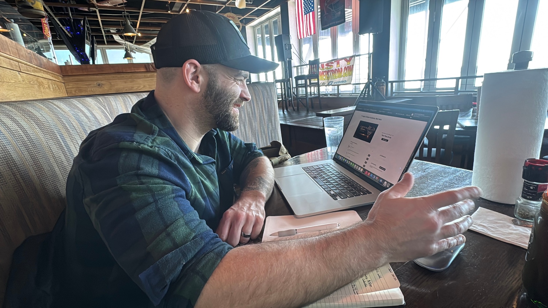 Jordan working from his laptop at a restaurant booth